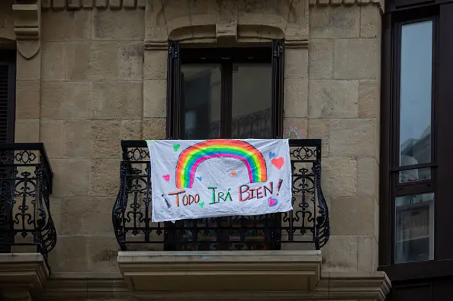 A poster with a rainbow drawn by children hangs on a balcony