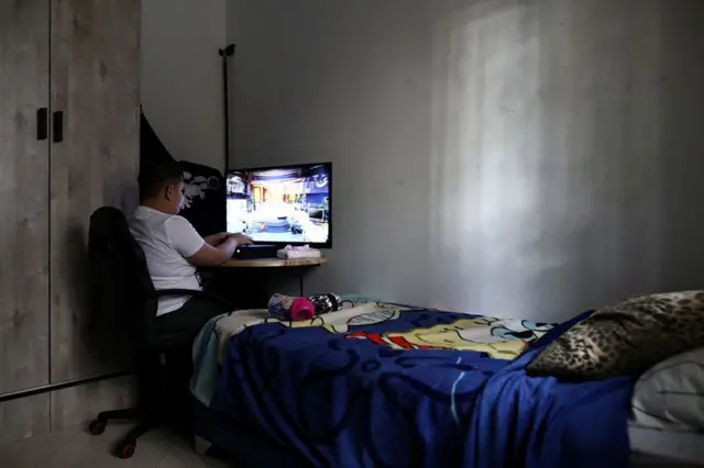 Palestinian Anton Victor Sara, 11, plays on a computer in his room while observing a partial lockdown at his home in Jerusalem.