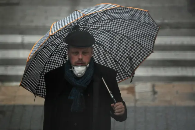 A person wears a face mask as he walks in Vilanova i la Geltru on March 30, 2020