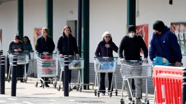 People queuing 2m apart outside a supermarket