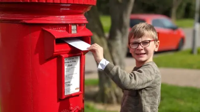 Boy posting a letter