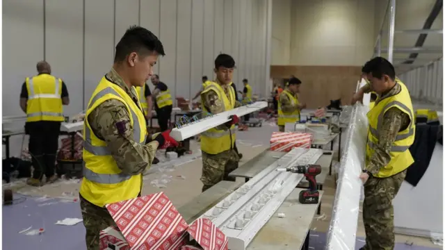 Military personnel helping to build the NHS Nightingale Hospital