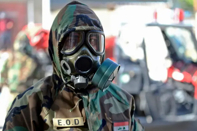 A member of the Iraqi civil defence prepares to disinfect a neighbourhood