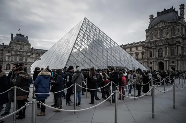 People queue outside the main entrance to the Louvre museum in Paris. Photo: 4 March 2020