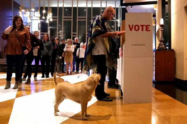 Eddie Craig Monarch reviews his ballot while his dog Sherlock waits at a polling place on Super Tuesday in Oklahoma City