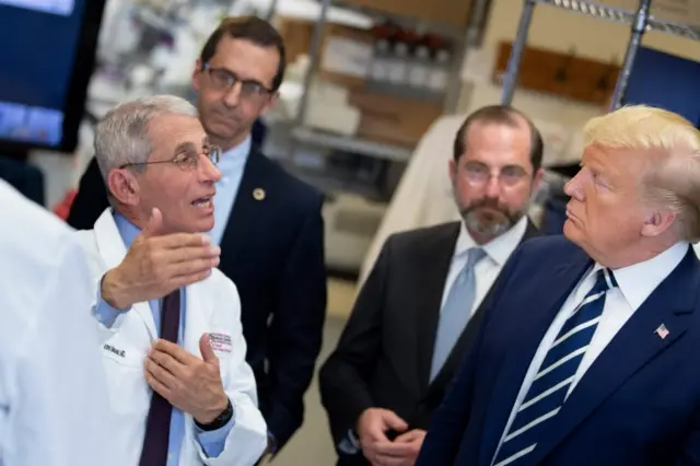 Tony Fauci (L) speaks to US President Donald Trump