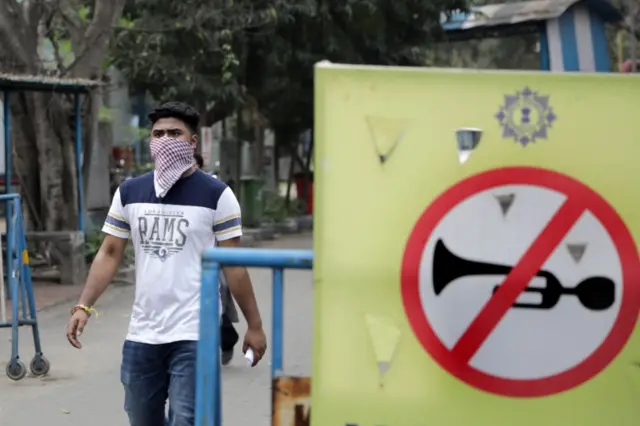 2 A man covers his face with a scarf as he walks around the Infectious Diseases Hospital in Kolkata