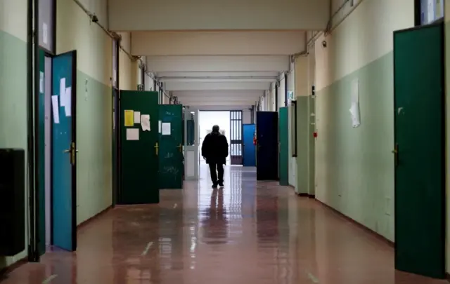 A man walks in a corridor at a school in Rome