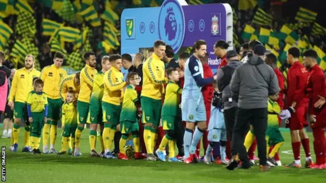 Norwich and Liverpool shake hands before a match