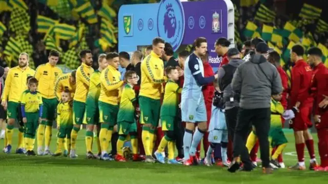 Norwich and Liverpool shake hands before their Premier League match