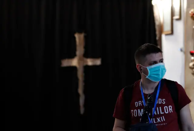 A mask-clad man visits the Church of the Nativity, in Bethlehem