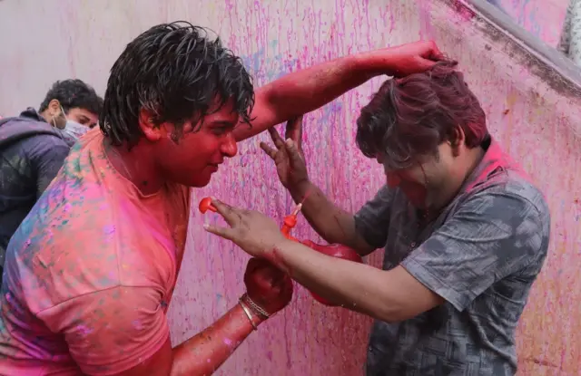 Hindu men celebrate the Lathmar Holi festival in Mathura, India