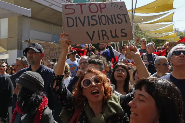 Greek Cypriots gather during a demonstration on either side of the Ledra Street crossing in central Nicosia