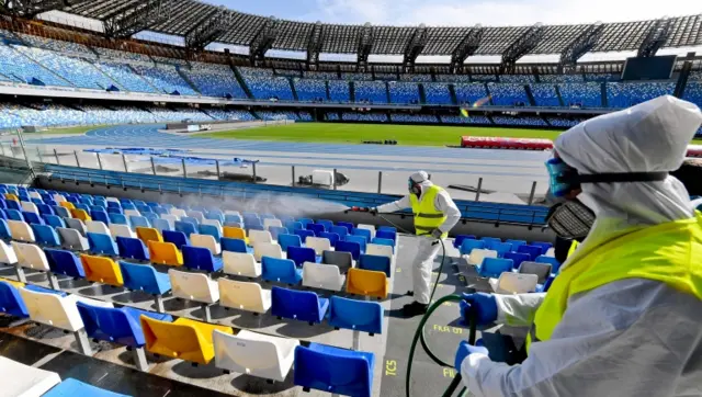 Cleaners wearing a protective suit, as they sanitise the seats of the San Paolo stadium