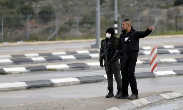 Members of the Israeli security forces stand next to a checkpoint in Jerusalem