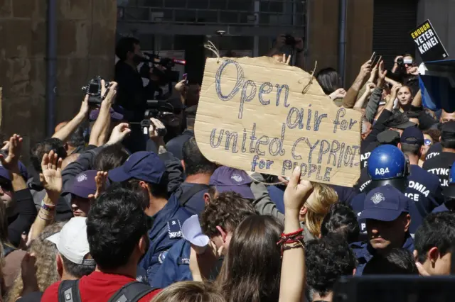 Cypriot protesters gather during a demonstration on either side of the Ledra Street crossing in central Nicosia