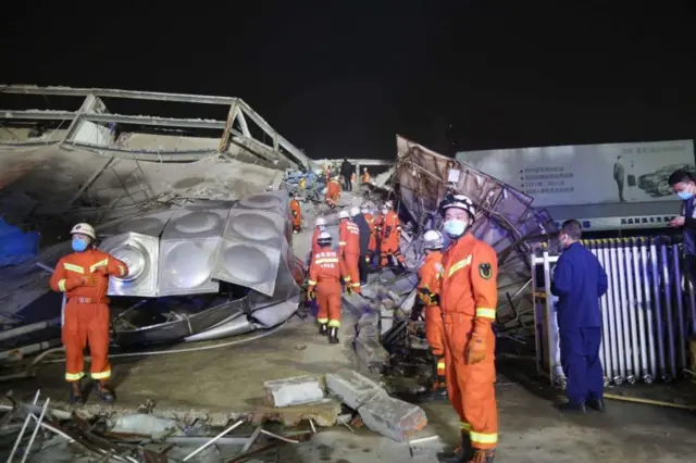 Rescuers work at the site of the collapsed five-storey hotel