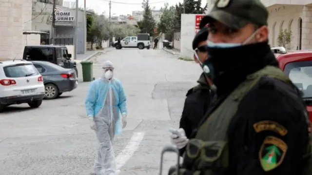 Medical staff and security forces outside a hotel in Beit Jala