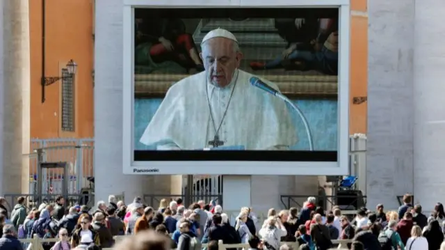 Pope Francis delivers his weekly Angelus prayer via video transmitted on the screen in St. Peter"s Square