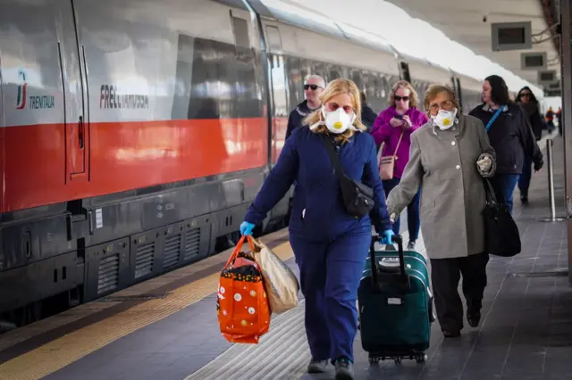 Passengers get off the train arriving from Milan, in Naples