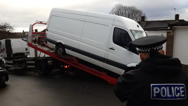 A white van on a tow truck