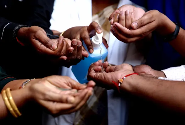 Medical officials in Bangalore, India, demonstrate to the public how to properly wash hands using sanitiser, during an awareness campaign