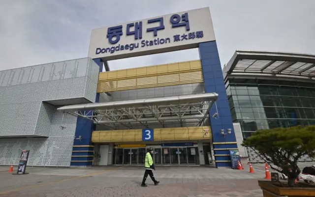 A man wearing a face mask walks in front of Dongdaegu railway station in the southeastern city of Daegu