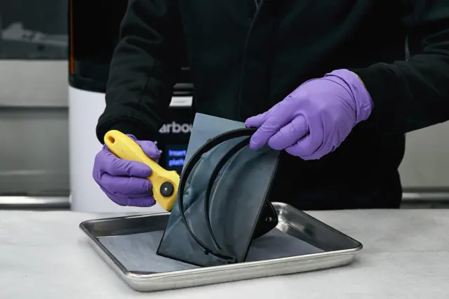 An employee at Lamborghini's factory in Bologna making medical shields.