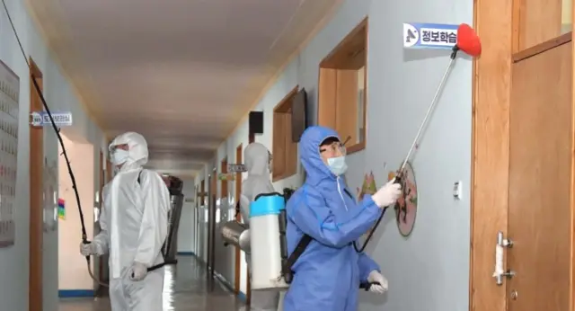 Workers disinfecting a building