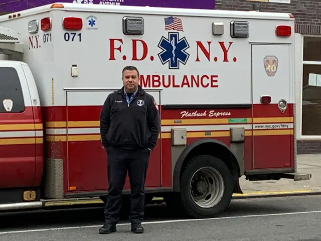 Anthony Almojera in front of an ambulance