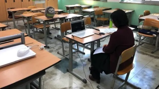 A teacher at a school in South Korea communicates with students via a laptop