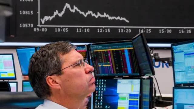 Trader in front of declining stock chart