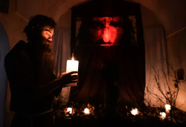 A monk from the Order of Friars Minor Capuchins prepares the tomb of Christ inside the Cloister Church in Krakow