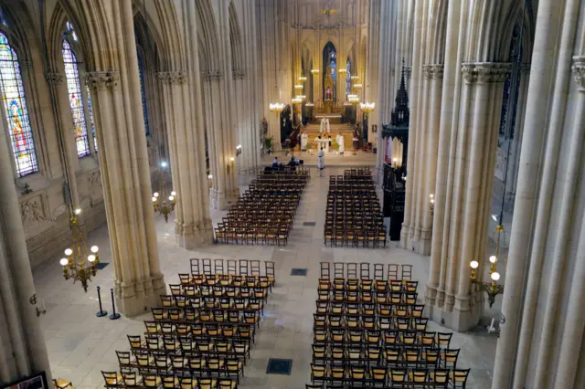 Father Marc Lambret leads Easter mass in an empty church with no congregation- except for those watching online - in Paris's Sainte-Clotilde basilica