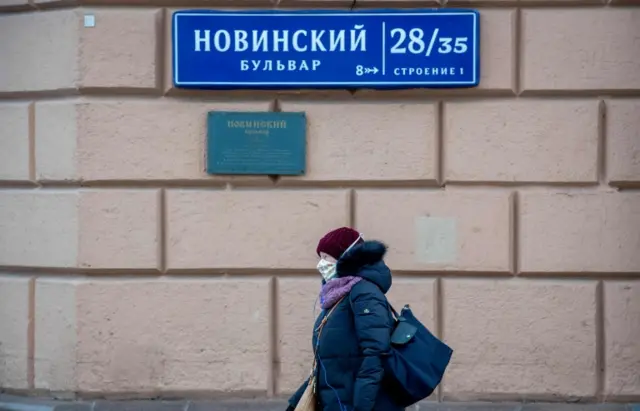 A woman wearing a face mask walks in central Moscow