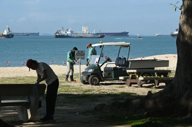 Workers closing off beaches in Singapore on 12 April 2020