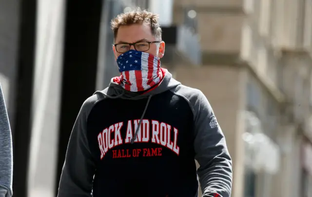 A man wearing home made mask walks along 5th Avenue amid the coronavirus pandemic on April 11, 2020 in New York City