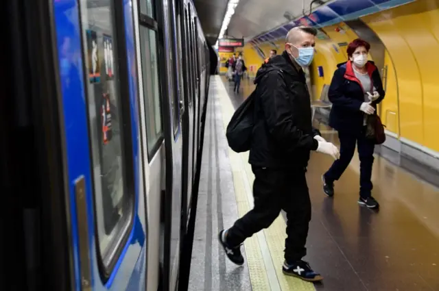 People in face masks use the metro in Madrid