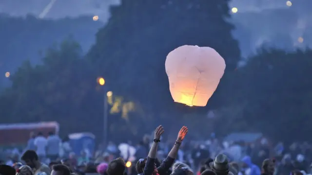 A person setting off a fire lantern