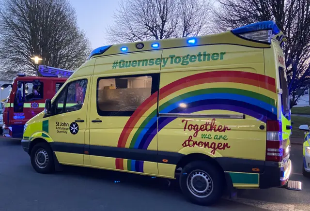 Rainbow ambulance with words #GuernseyTogether and together we are stronger painted on