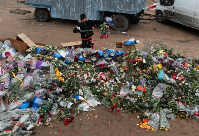 An employee dumps unsold flowers in St Petersburg, Russia. Photo: 13 April 2020