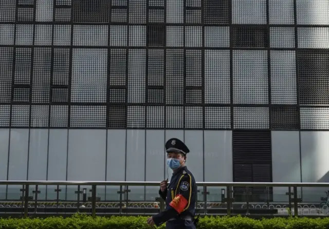 A security guard wears a mask outside a building in Beijing