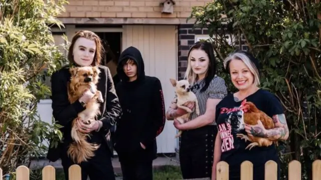 A chicken and dogs feature in this family portrait