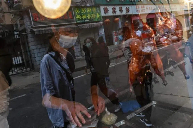 A man in a mask sells ducks in a shop in Wuhan, China. Photo: 14 April 2020