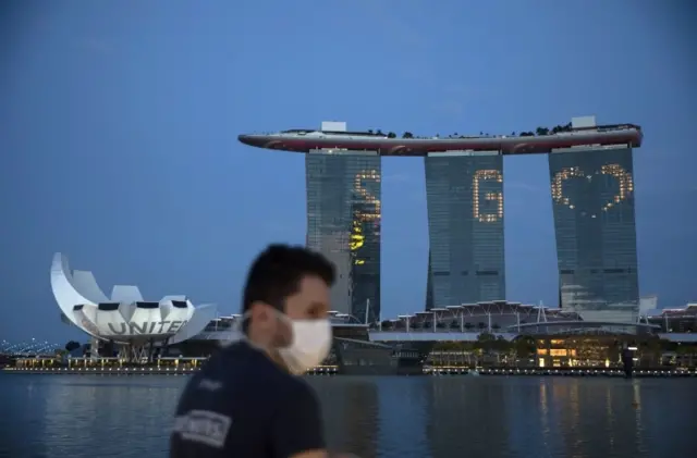 A man walks in Singapore while wearing a mask