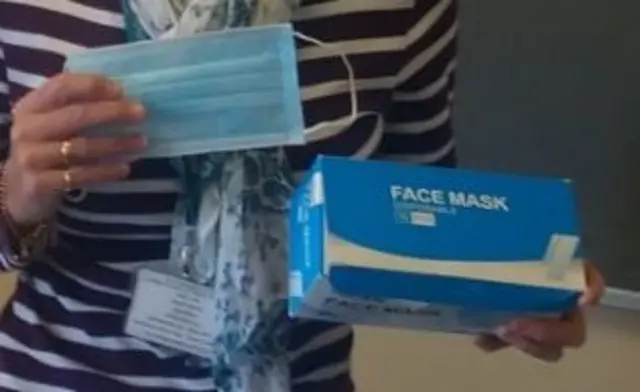 Woman holding face mask