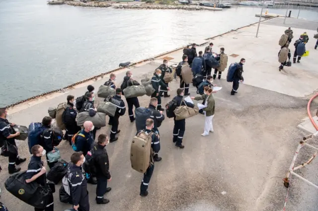 French navy handout showing sailors coming ashore from Charles de Gaulle