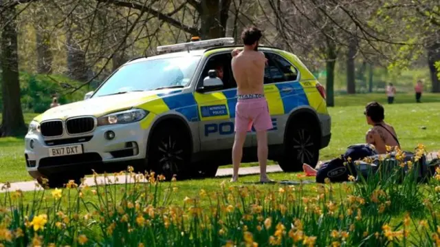 Police near people sat in park