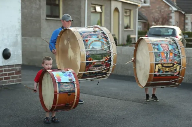 Mark Black and his son play the drums during the 8pm applause