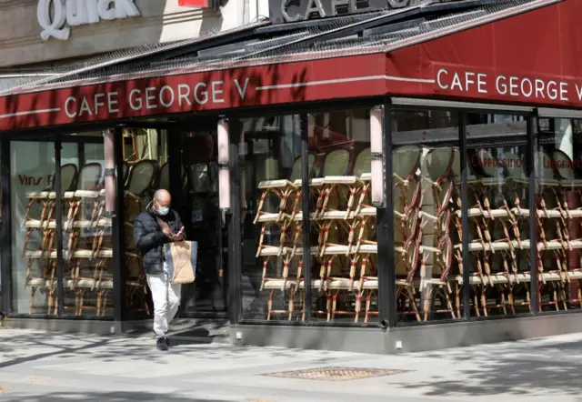 A man wearing a mask walks through the streets of Paris